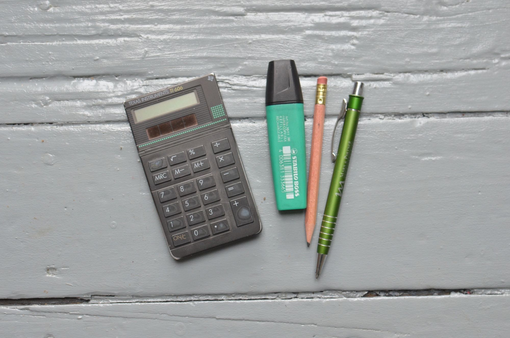 Calculator and stationery arranged on a light work surface